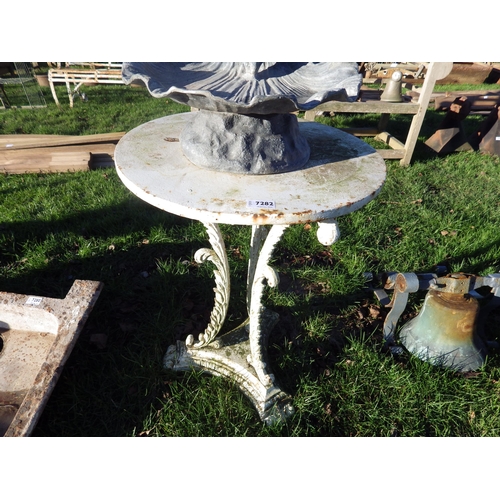 7282 - A cast iron tripod based garden table, round top