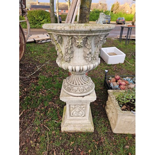 7120 - A modern composition urn planter with satyr and grape and vine detail, upon a square plinth base, 41... 