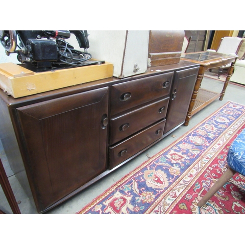 2351 - An Ercol elm sideboard, three central drawers flanked by twin cupboards   (E) £30-50