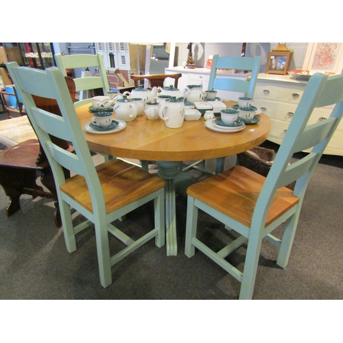 1106 - An oak kitchen table and four chairs, the natural circular top over green painted base, 76cm tall x ... 