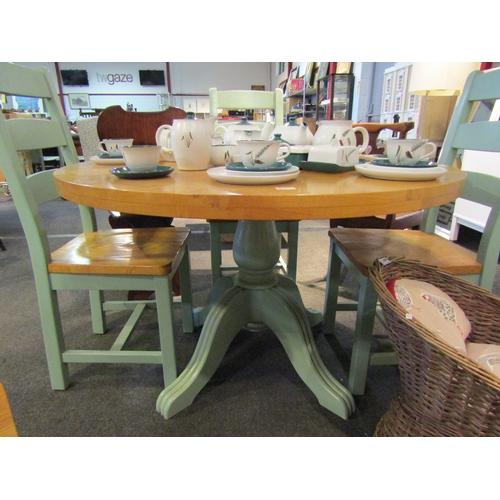 1106 - An oak kitchen table and four chairs, the natural circular top over green painted base, 76cm tall x ... 