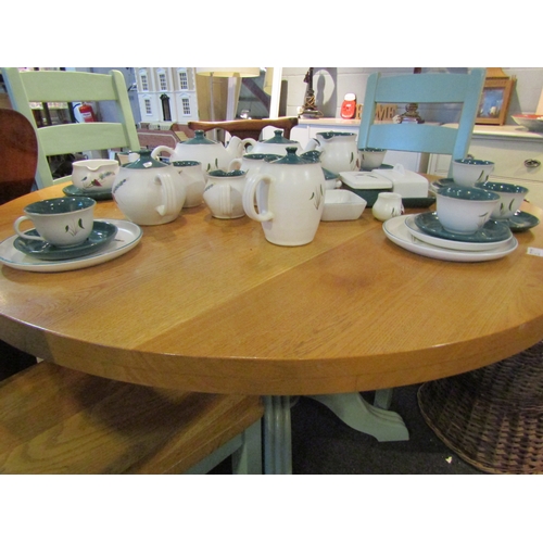 1106 - An oak kitchen table and four chairs, the natural circular top over green painted base, 76cm tall x ... 