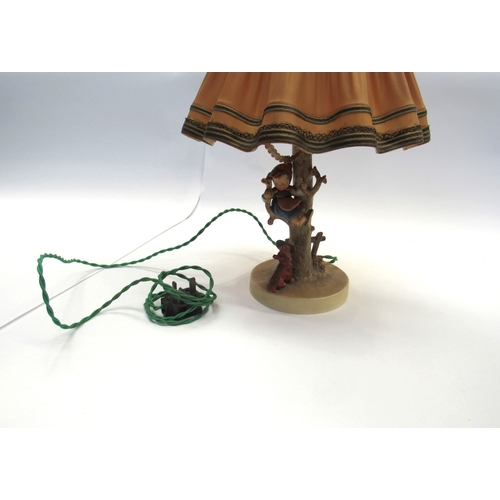 8003 - A Goebel late 1940's table lamp, young girl perched on a tree with dog at her feet holding her slipp... 