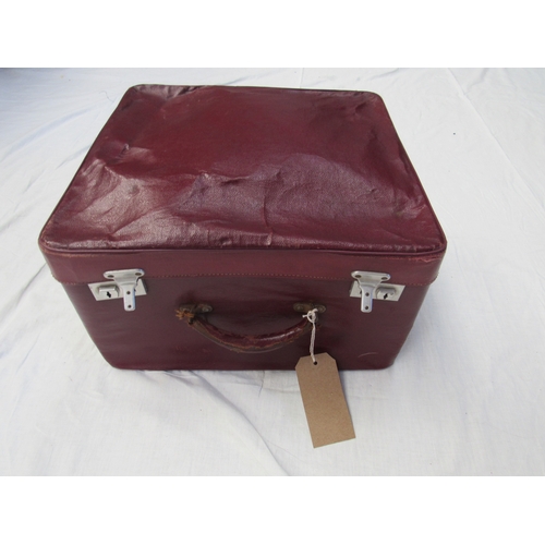 8044 - A small burgundy leather traveling case with original travel provenance labels containing mainly lad... 