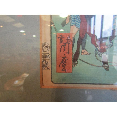 1017 - A Japanese woodblock print of a travelling salesman. Framed and glazed. 32.5cm x 22cm image size