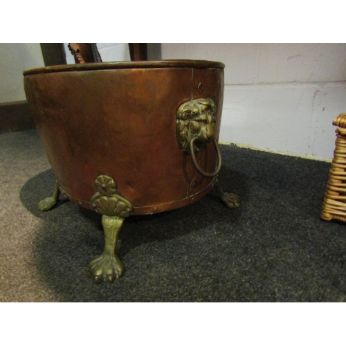 1042 - A copper and brass coal basket on paw feet with lion mask handles together with three fireside tools