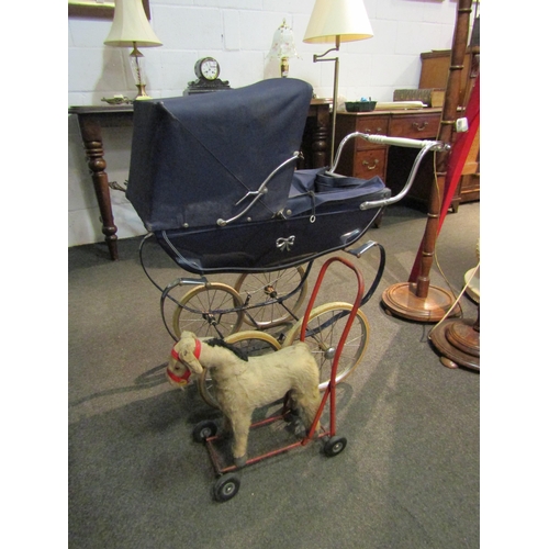 1057 - A Silvercross doll's pram and a push along toy dog, worn (2)