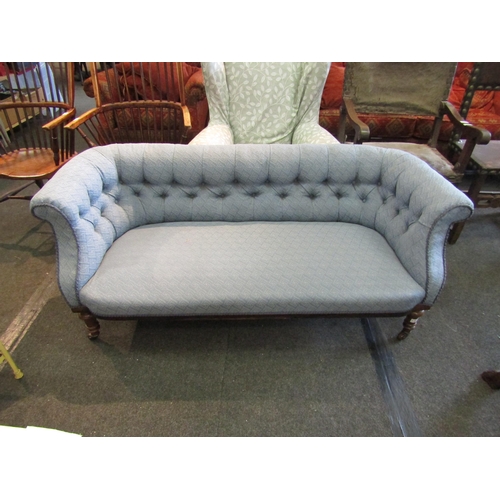 1179 - A Victorian walnut settee, buttoned pale blue upholstery, turned supports to castors. 158cm L x 67cm... 