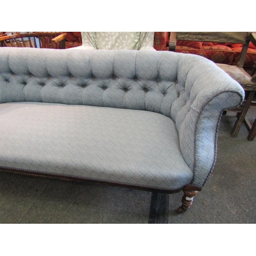 1179 - A Victorian walnut settee, buttoned pale blue upholstery, turned supports to castors. 158cm L x 67cm... 