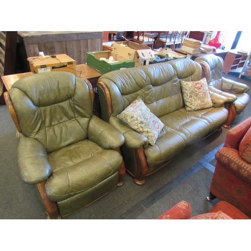 1163 - A four piece leather and oak framed suite comprising of a three seater sofa, armchair, reclining arm... 