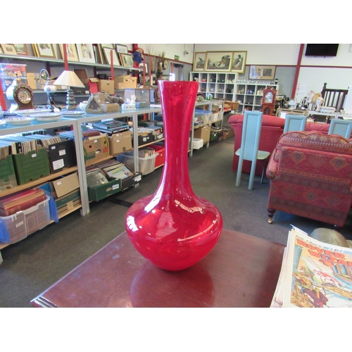 1168 - A ruby glass vase 51cm tall, together with a floor standing five branch candle holder 97cm tall