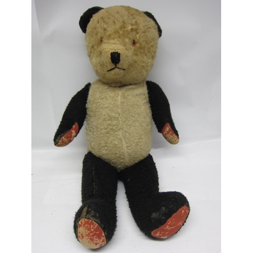 8283 - A vintage straw filled panda teddy bear with articulated limbs, 70cm tall