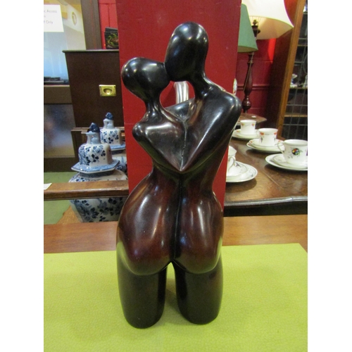 4061 - A heavy modernistic figure of an embracing couple, 28cm tall