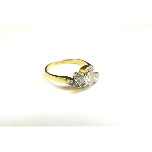 9286 - An 18ct gold ring set with three diamonds in diamond set crossover shoulders, the centre diamond 0.5... 