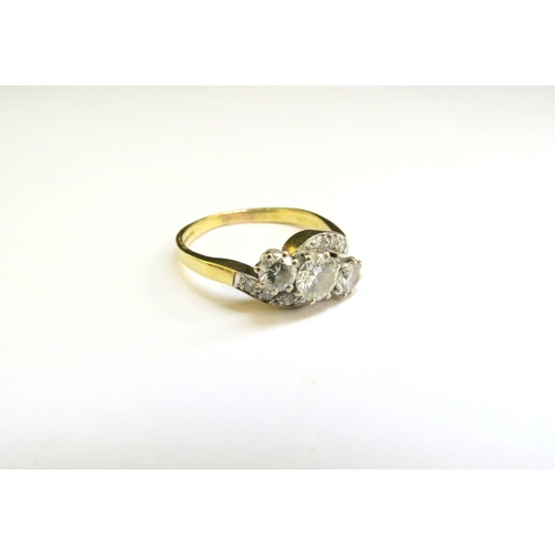 9286 - An 18ct gold ring set with three diamonds in diamond set crossover shoulders, the centre diamond 0.5... 