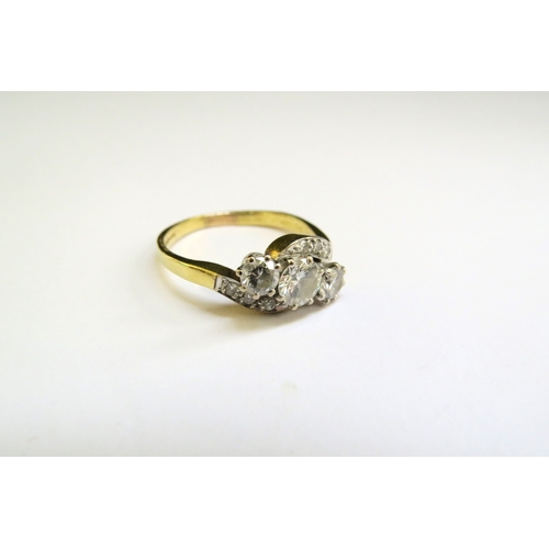 9286 - An 18ct gold ring set with three diamonds in diamond set crossover shoulders, the centre diamond 0.5... 