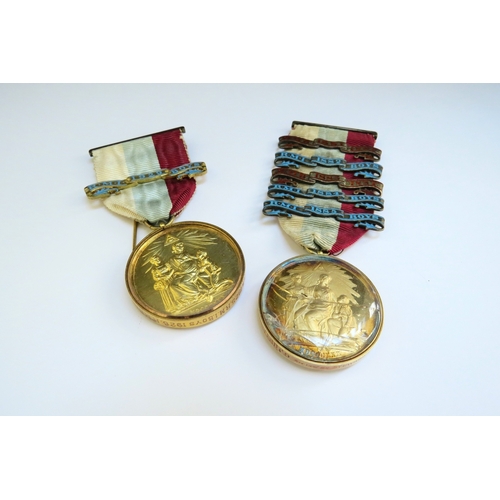 9358 - Two silver gilt Masonic medals in glass capsules one with a 15ct gold mount the other 9ct gold, on r... 