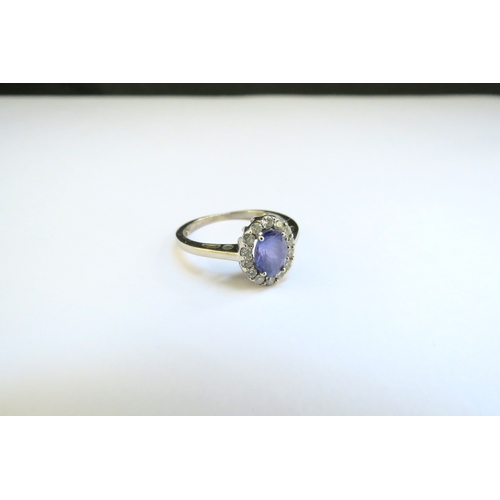 9139 - A 9ct white gold tanzanite and diamond cluster ring. Size M, 2.5g, with purchase receipt