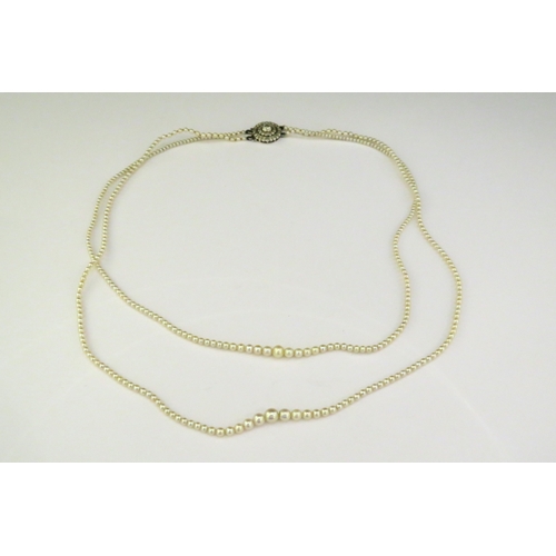 9143 - A double row of fine graduated pearls with a diamond cluster fastening, 46cm longest row