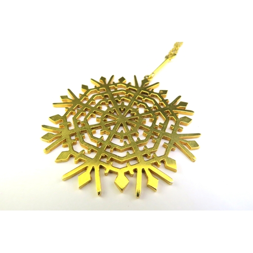 9141 - A large 9ct gold snowflake pendant 5.5cm diameter hung on a gold rope twist necklace, 52cm long, 22.... 