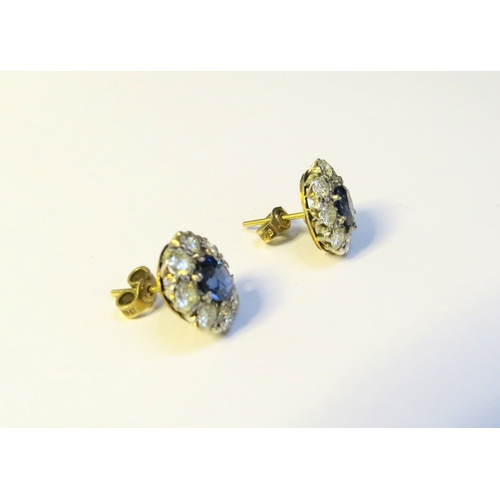 9268 - A pair of sapphire and diamond cluster earrings, the centre oval sapphire 6mm x 5mm, framed by eight... 