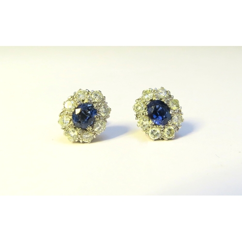 9268 - A pair of sapphire and diamond cluster earrings, the centre oval sapphire 6mm x 5mm, framed by eight... 