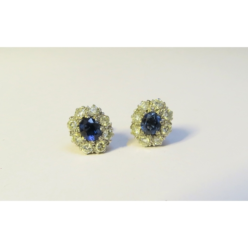 9268 - A pair of sapphire and diamond cluster earrings, the centre oval sapphire 6mm x 5mm, framed by eight... 