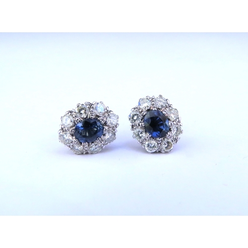 9268 - A pair of sapphire and diamond cluster earrings, the centre oval sapphire 6mm x 5mm, framed by eight... 