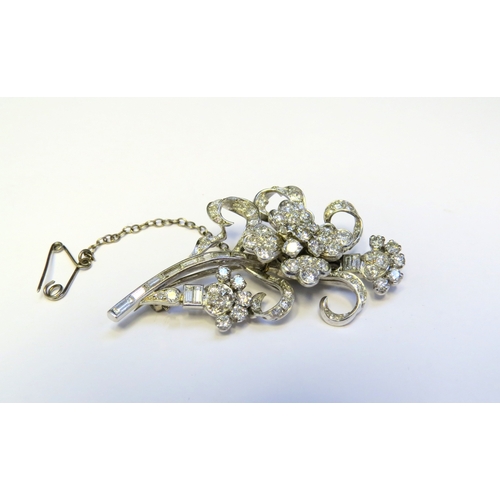 9151 - A diamond encrusted brooch as a floral spray, 3ct plus of brilliant and baguette cut diamonds, 5cm x... 