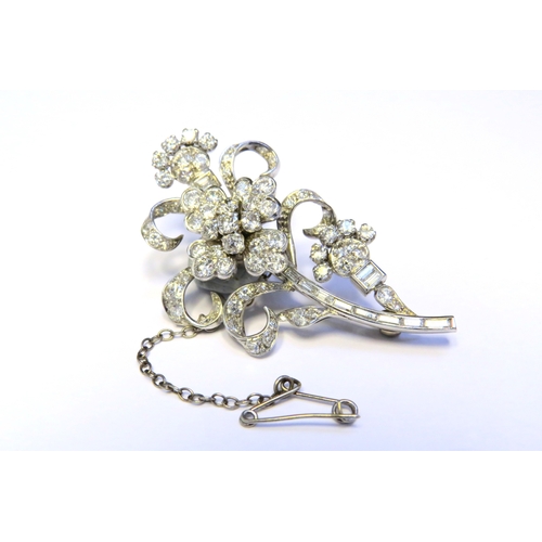 9151 - A diamond encrusted brooch as a floral spray, 3ct plus of brilliant and baguette cut diamonds, 5cm x... 