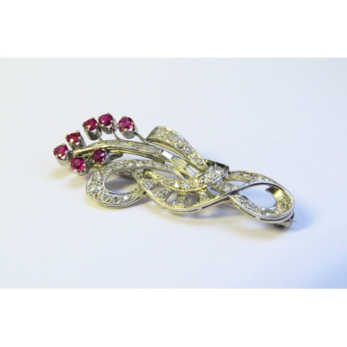 9153 - A diamond and ruby encrusted brooch as a floral sprig, with brilliant and baguette cut diamonds, 4.5... 