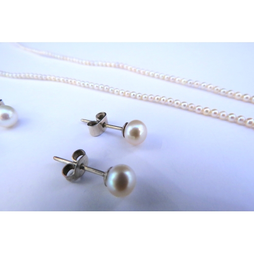 9318 - A single strand fine pearl necklace and two pairs of pearl stud earrings