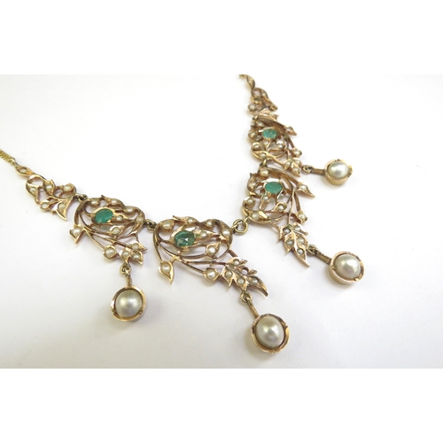 9187 - An emerald and seed pearl studded necklet the central four panels hung with a pearl droplet, on late... 