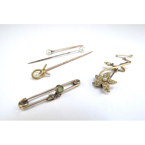 9246 - Two gold brooches one as a seed pearl set flower and a gold stick pin, unmarked, 7.6g