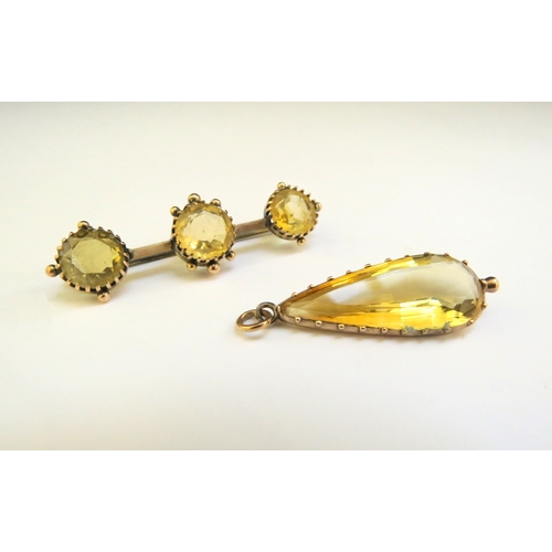 9326 - A citrine coloured pear shaped pendant and similar brooch, unmarked