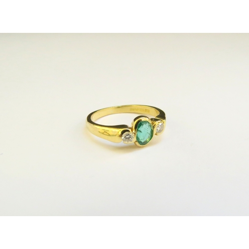 9209 - An 18ct gold emerald and diamond ring, the central oval emerald flanked by diamonds in twist setting... 