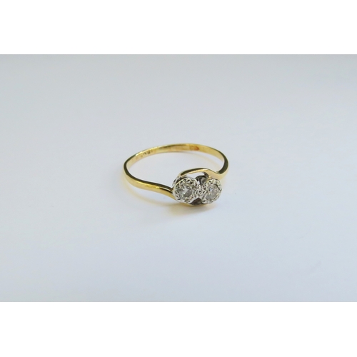 9338 - A two stone diamond crossover ring, stamped 18ct. Size L, 1.3g