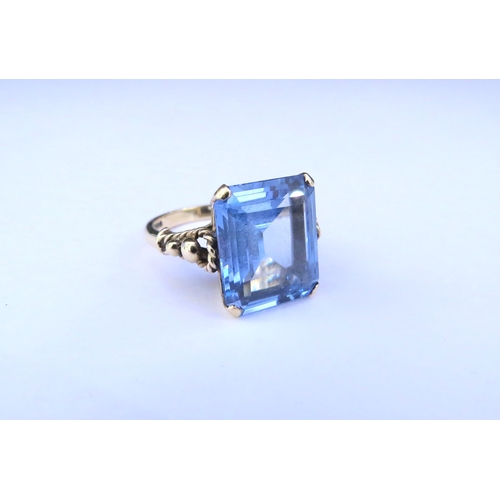 9311 - A 9ct gold ring with large rectangular blue stone. Size M/N, 5.8g