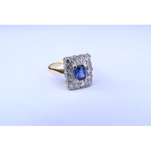 9146 - An 18ct gold sapphire and diamond ring, the central oval sapphire framed by fourteen diamonds in rec... 