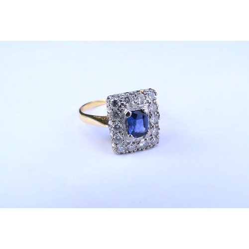 9146 - An 18ct gold sapphire and diamond ring, the central oval sapphire framed by fourteen diamonds in rec... 