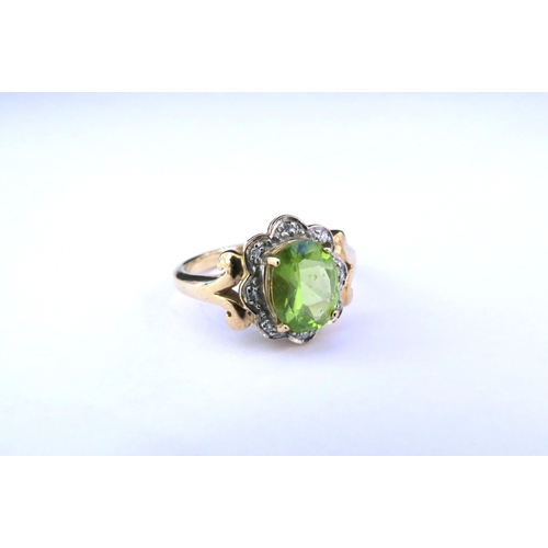 9149 - A 9ct gold peridot and diamond ring, the central oval peridot framed by diamond chips. Size N/O, 3.9... 