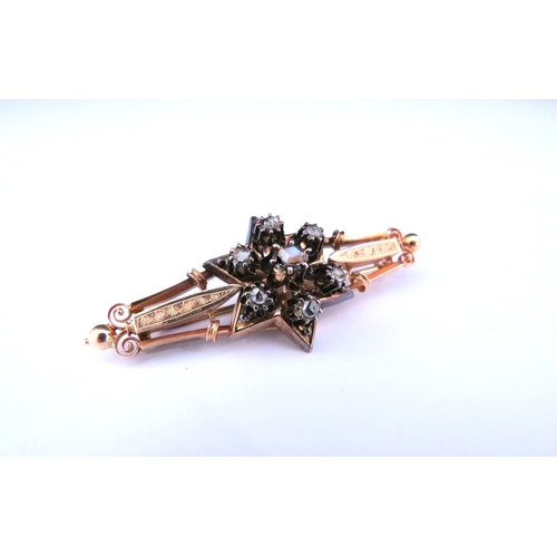 9220 - An unmarked gold brooch with six point star to centre set with seven old cut diamonds 5.5cm long, 5.... 