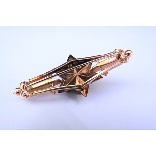 9220 - An unmarked gold brooch with six point star to centre set with seven old cut diamonds 5.5cm long, 5.... 