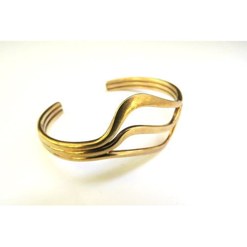 9291 - WITHDRAWN: A 9ct gold cuff bangle, wavy design, 22.8g