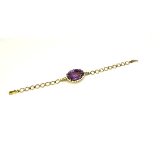 9343 - A bracelet centrally set with an oval amethyst framed by clear stones, unmarked, 16.5cm long