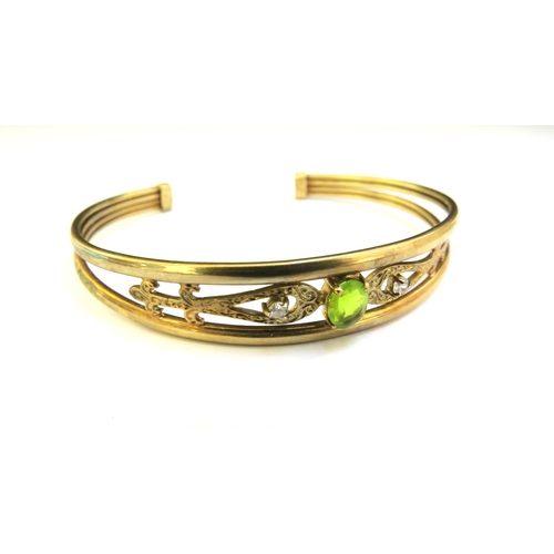 9249 - A 9ct gold cuff bangle set with an oval peridot, 10.6g