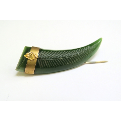 9202 - A carved Nephrite jade tooth shaped pin with mount stamped 9ct  (R)  £70