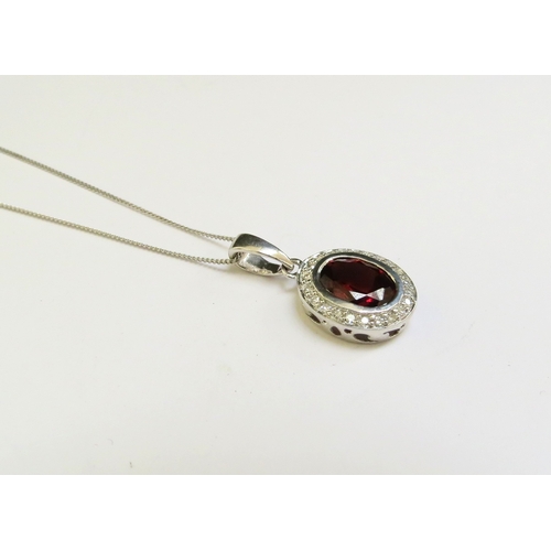 9162 - A white gold garnet and diamond cluster pendant hung on 9ct white gold chain, 46cm long, 2.4g