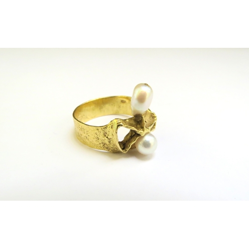 9254 - A textured gold ring of modernistic design with two pearls on abstract mount, stamped 750. Size P/Q,... 