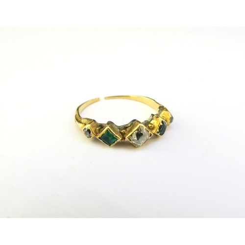 9341 - A gold ring set with two emeralds and three diamonds, shank worn, split and repair present. Size L, ... 